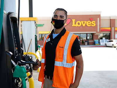 love's employee wearing reflective vest changing receipt paper at fuel pump