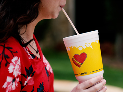 woman drinking iced tea in Love's fountain drink cup