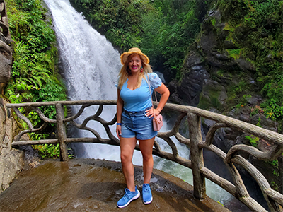 A women standing in front of a waterfall. 