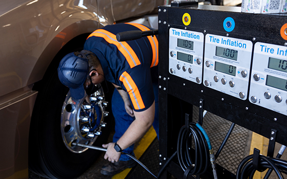 A photo of a truck care technician performing TirePass service